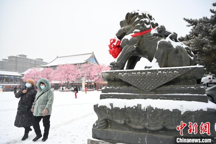 2月13日，民众在呼和浩特市大召广场雪中漫步。　刘文华 摄