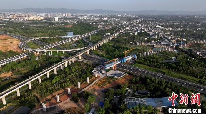 航拍正在建设的跨越成都绕城高速公路连续梁施工现场，旁边依次为已运营的成渝高速铁路和机场高速公路。　刘忠俊 摄