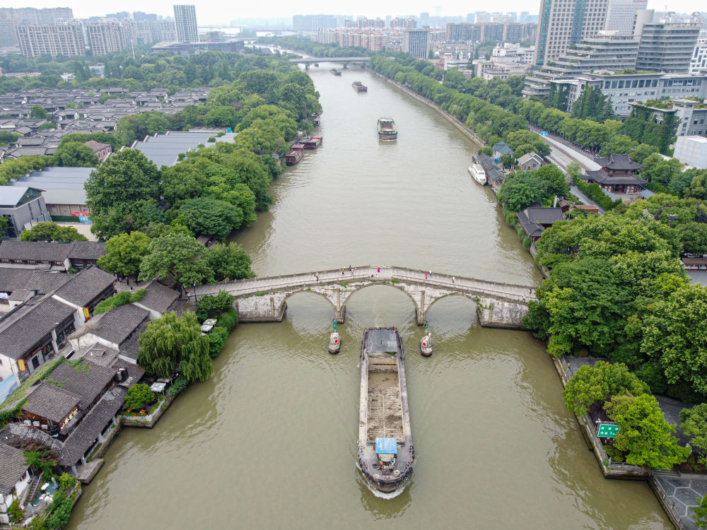 5月27日，一艘货船驶过京杭大运河南端标志建筑杭州拱宸桥。(无人机照片)新华社记者江汉 摄