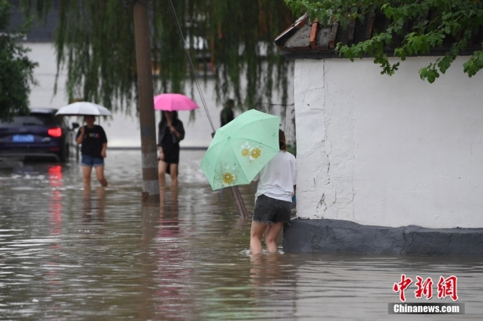 7月31日，市民行走在雨中的北京房山区瓦窑头村。北京市气象台当日10时发布分区域暴雨红色预警信号。北京市水文总站发布洪水红色预警，预计当日12时至14时，房山区大石河流域将出现红色预警标准洪水。<a target='_blank' href='/'><p  align=