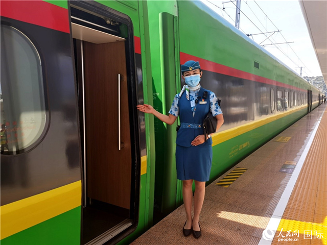 赵莹静站在“复兴号”国际旅客列车车厢门口欢迎旅客上车。人民网 杜明明摄