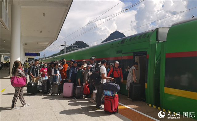 乘坐中老铁路国际旅客列车的旅客在老挝琅勃拉邦站排队上车。人民网记者 杜明明摄