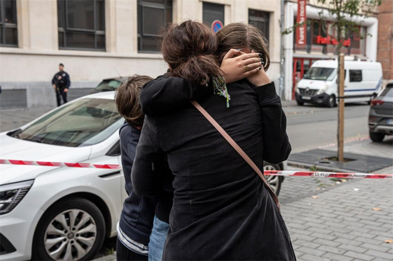 10月13日，在法国北部城市阿拉斯发生袭击事件的甘贝塔高中外，一名家长安慰学生。新华社发