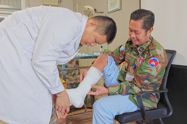中国第22批赴黎维和医疗分队军医为患者打石膏固定患肢。李清竹摄
