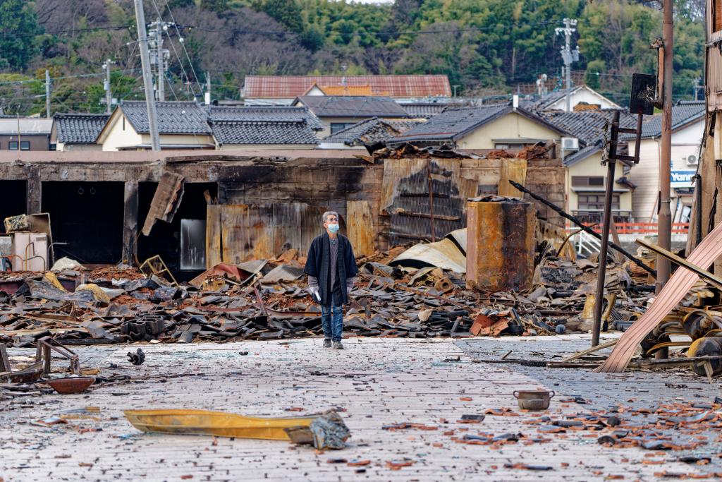 1月4日，一名市民查看日本石川县轮岛市“轮岛早市”废墟。新华社记者张笑宇摄