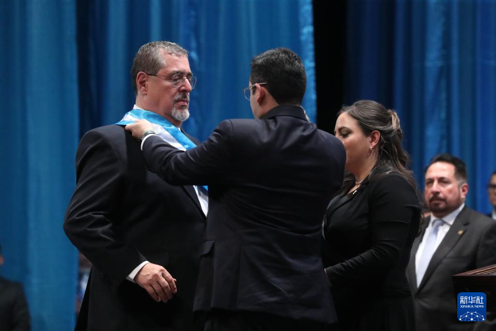 1月15日，在危地马拉首都危地马拉城的国家剧院，贝尔纳多·阿雷瓦洛（左）接过总统绶带。新华社发（贡萨洛·佩雷斯摄）