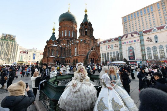 2月12日，旅拍游客在哈尔滨建筑艺术广场身着盛装拍照。（新华社记者王建威摄）