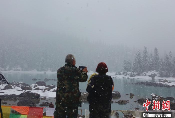 游客欣赏雪中然乌湖。　冉文娟 摄