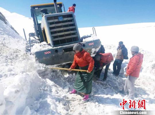 图为普布卓玛(左一)与养护工人一起抗击雪灾，抢险保通。　阿里地区公路养护段供图 摄