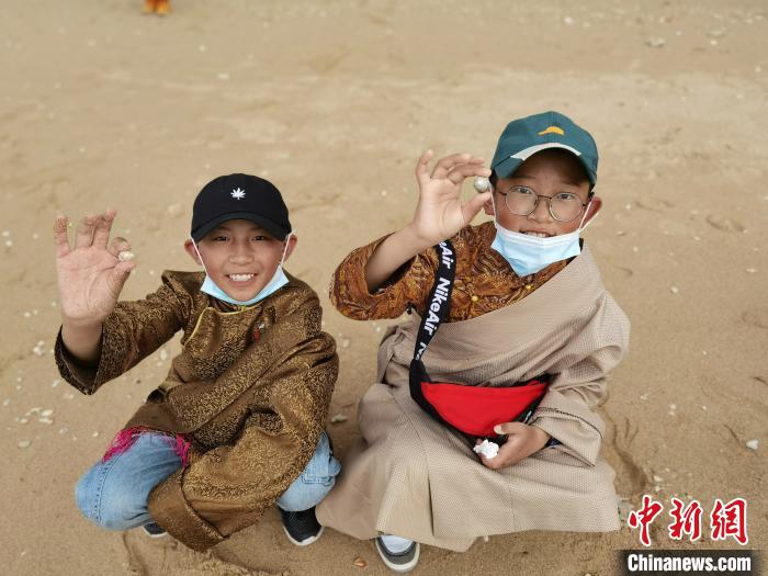 图为西藏青少年在海边拾贝壳。西藏航空 供图