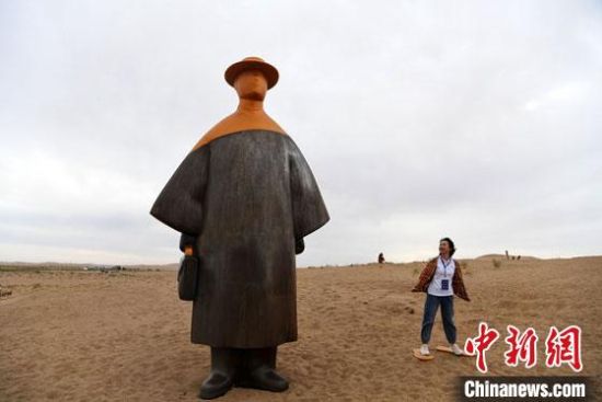 　2020年9月5日，甘肃民勤县沙漠里的雕塑作品《丝路旅人》吸引民众。(资料图) 杨艳敏 摄