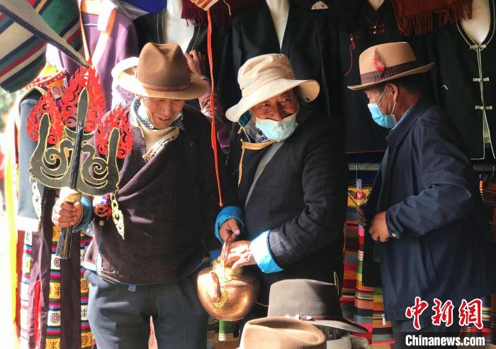 图为三位藏族老人在集市上聊天交谈。　冉文娟 摄
