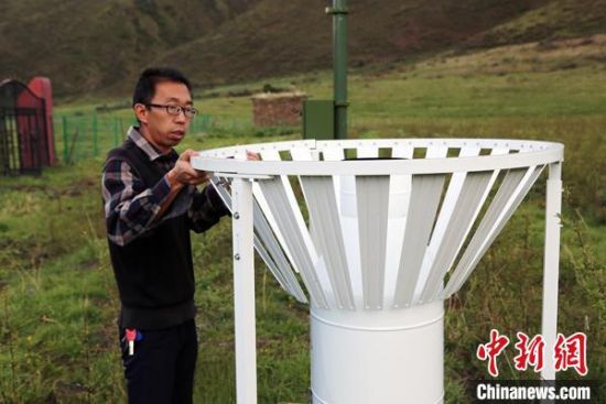 图为班玛县气象局工作人员在维护藏雪茶基地气候站。青海省气象局供图