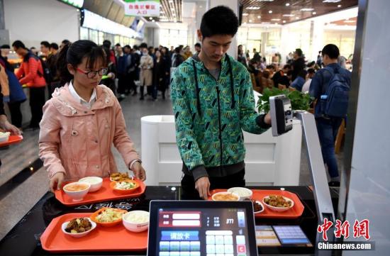 资料图：某高校食堂学生在打饭。中新社记者 韩苏原 摄