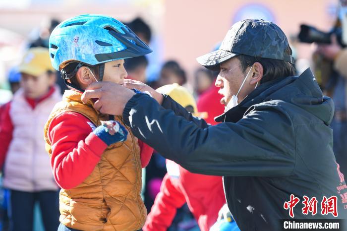 图为拉萨市实验幼儿园孩子在教练的帮助下穿戴头盔。　何蓬磊 摄