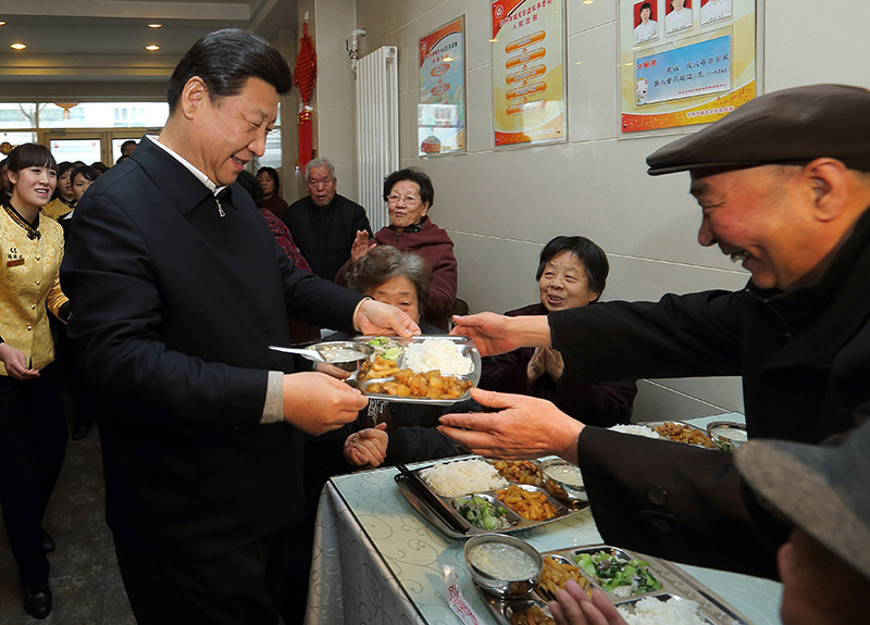 2013年2月4日，习近平总书记来到兰州一家“虚拟养老院”的养老餐厅，了解有关情况，还端起一个盛满饭菜的餐盘，走到72岁的老人杨林太面前，轻轻送上，请他用餐。