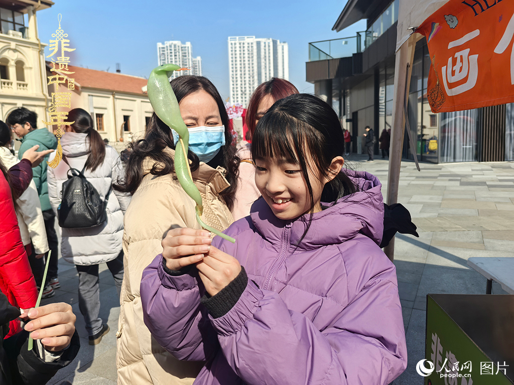 2025年1月29日，湖北武汉的新春庙会上，小朋友拿着吹制好的糖人，十分开心。人民网记者 张沛摄