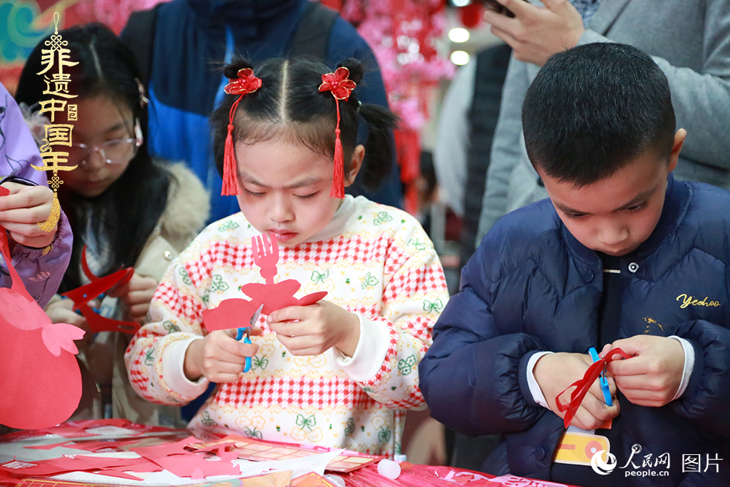 2025年1月23日，上海市青少年活动中心迎新春游园会上，小朋友们正在学习剪窗花。人民网记者 龚莎摄