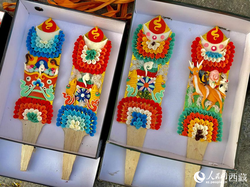 插在切玛盒上的仔卓（仔卓也叫酥油花，是藏民族雕塑艺术的一种特殊形式，以酥油为原料，以人物、花卉、树木、飞禽、走兽等为主题的一种手工油塑艺术）。人民网 次仁罗布摄