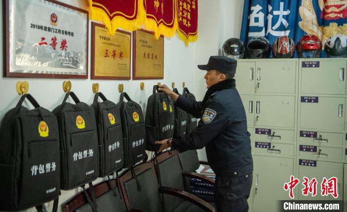 甲学镇派出所值班室，8个“警务背包”挂在墙上依次排开 刘忠俊 摄