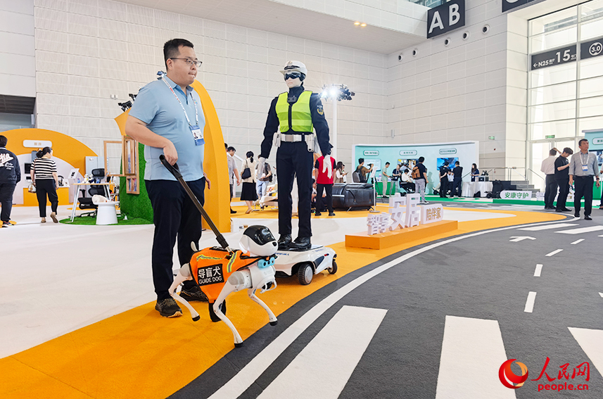 “机器人小镇”里导盲犬机器人引导体验者过“马路”。人民网记者 陶建摄