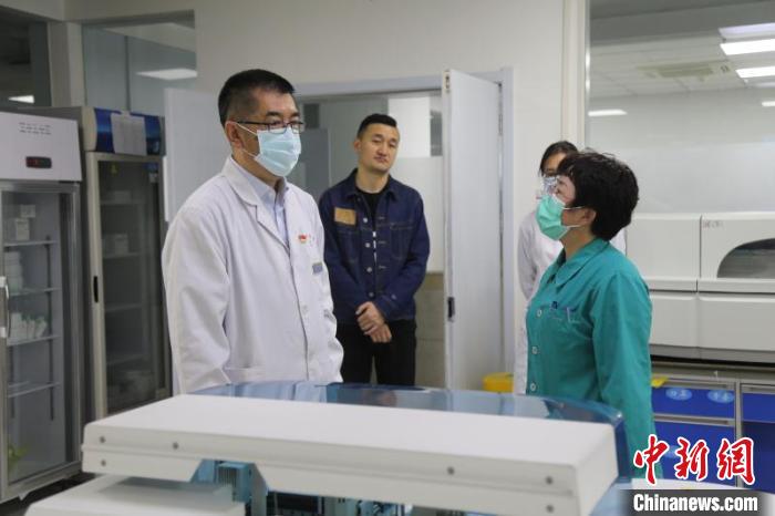 图为陶宝忠(左一)在检查科与医护人员交流。(资料图)青海省第四人民医院供图