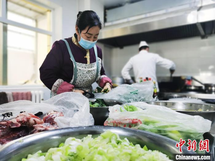 图为尖扎县残疾人托养服务中心食堂工作人员烹饪午餐。 张添福 摄