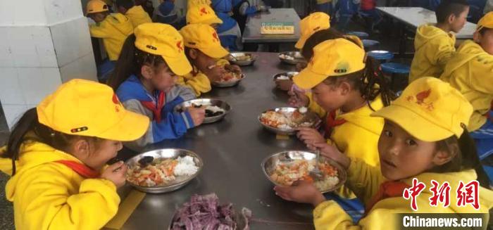 图为学生享受“三包”政策，在学校食堂吃上了免费营养餐。　尼玛江热乡中心小学供图 摄