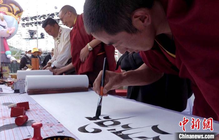 图为在“松赞夜市”非遗展台僧人书写藏文书法。　贡桑拉姆 摄