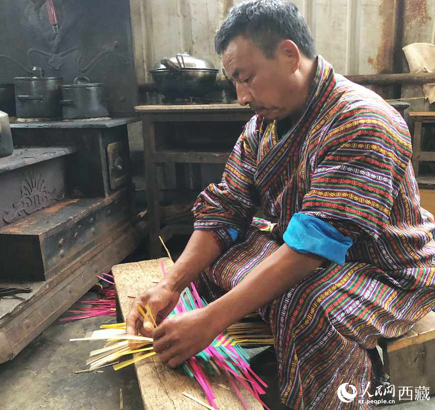 门巴族汉子爱明正在编织藤竹品。