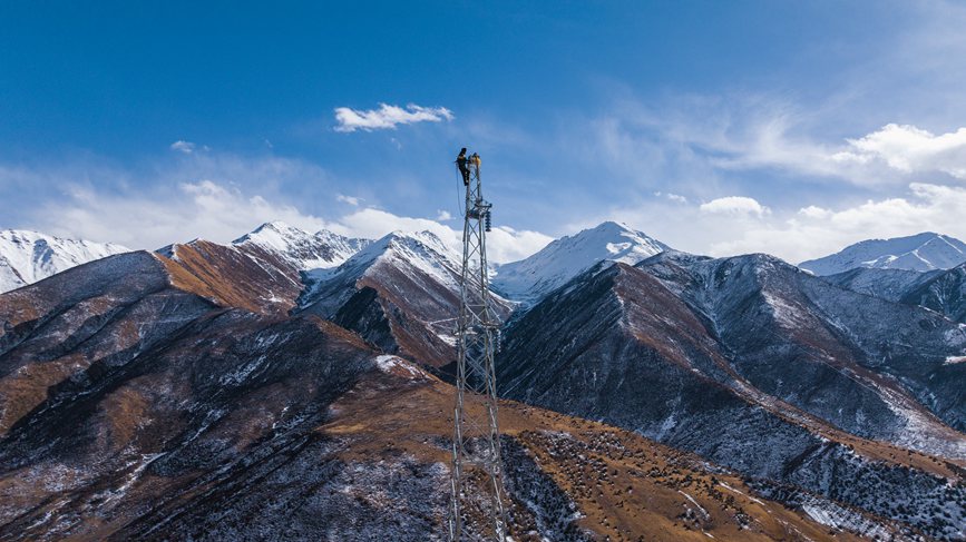 2023年11月30日，西藏自治区那曲市索县荣布至丁青县巴达35千伏线路工程施工人员正在开展塔上作业。赵清鹏摄