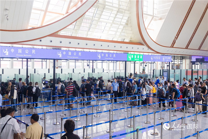 乘坐中老铁路国际旅客列车的旅客在磨憨边检大厅排队候检。卫海林 摄