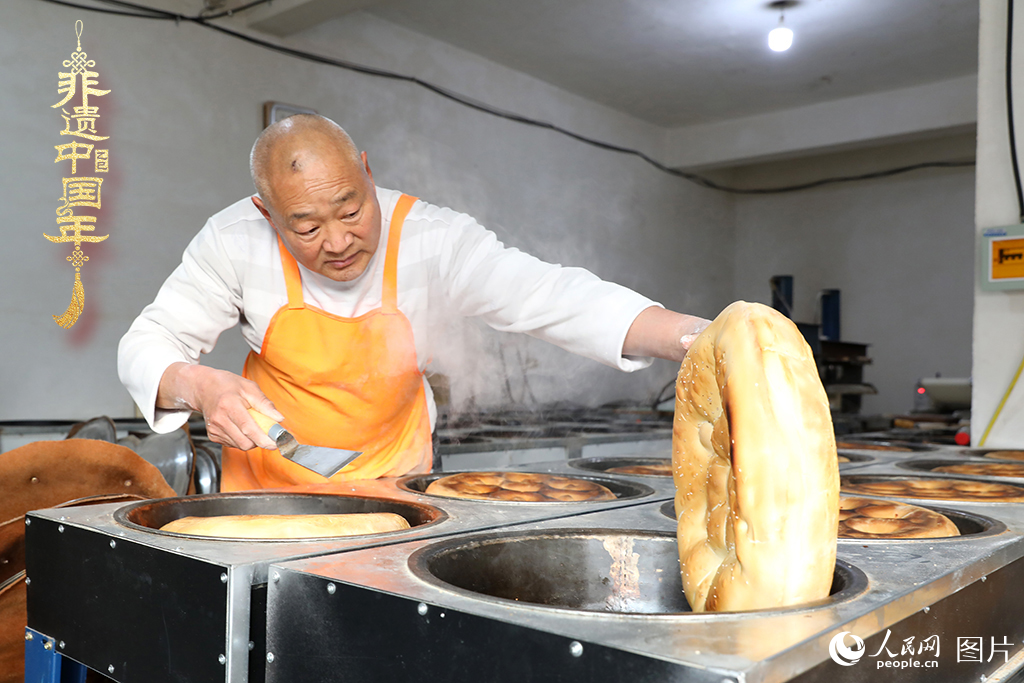 2025年1月23日，山东省临沂市莒南县一家传统大饼作坊内，师傅们正忙着烤制当地人春节期间家家户户必备的、金黄诱人的莒南大饼。人民网记者 刘祺摄